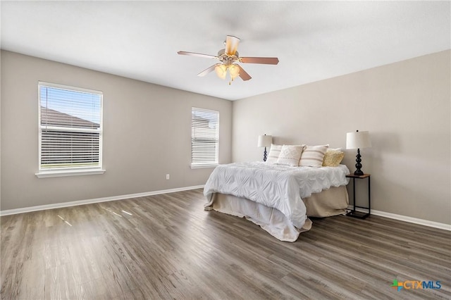 bedroom featuring ceiling fan, baseboards, and wood finished floors