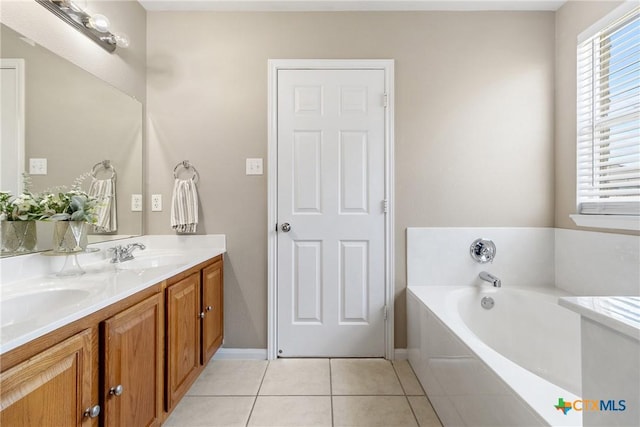 bathroom with tile patterned floors, a bath, double vanity, and a sink