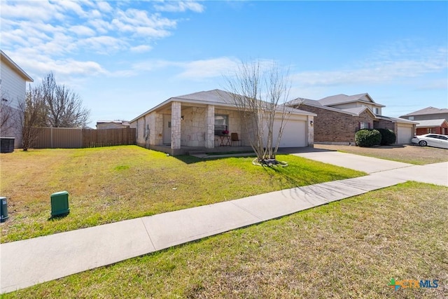 view of front facade with fence, driveway, a front lawn, a garage, and stone siding