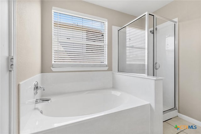 full bathroom featuring tile patterned flooring, a shower stall, and a bath