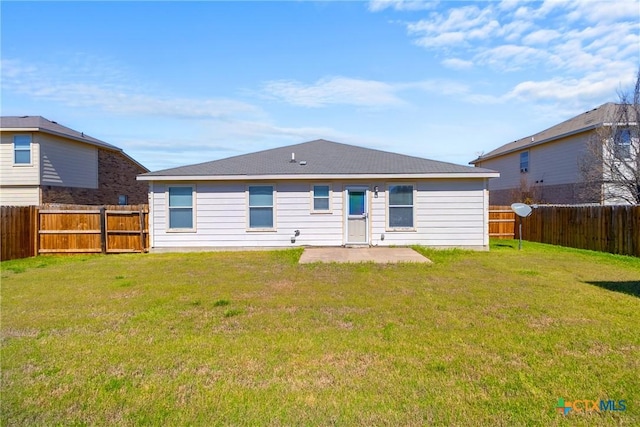 rear view of house featuring a yard, a fenced backyard, and a patio area