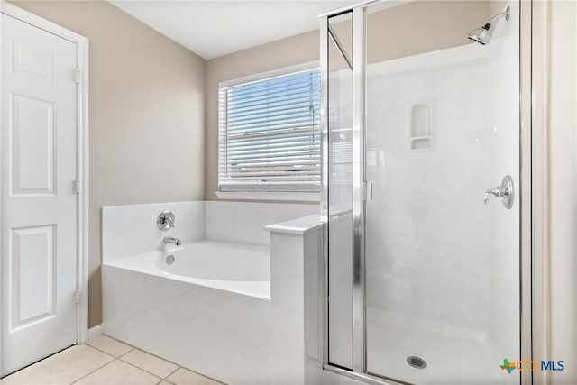 bathroom with tile patterned floors, a garden tub, and a shower stall