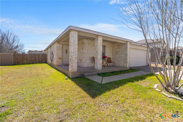 view of front of home with fence, a front lawn, concrete driveway, a garage, and stone siding