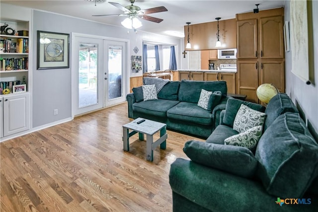904 Iola St, Victoria, TX 77904 - living area featuring french doors, light wood finished floors, ceiling fan, baseboards, and built in shelves