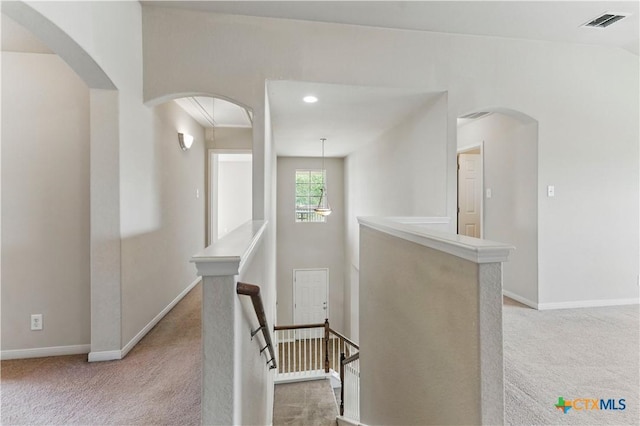 2441 Ibis Ave, New Braunfels, TX 78130 - hallway featuring carpet, arched walkways, visible vents, an upstairs landing, and baseboards