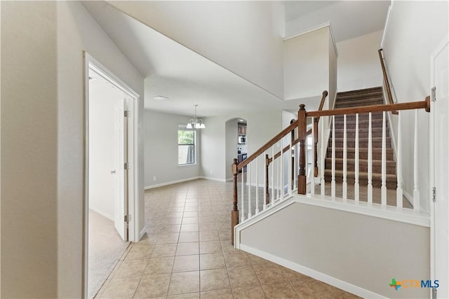 2441 Ibis Ave, New Braunfels, TX 78130 - staircase with arched walkways, tile patterned flooring, a notable chandelier, and baseboards