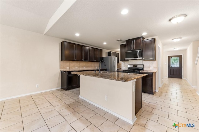 10055 Strasbourg Way, Schertz, TX 78154 - kitchen featuring stainless steel appliances, tasteful backsplash, light tile patterned flooring, dark stone counters, and recessed lighting