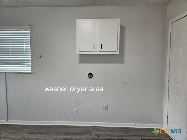 clothes washing area with dark wood-type flooring, cabinets, a textured ceiling, and hookup for an electric dryer