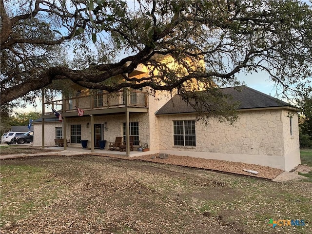 448 Summer Glen Ln, New Braunfels, TX 78132 - back of property with a balcony, stone siding, a patio area, and roof with shingles