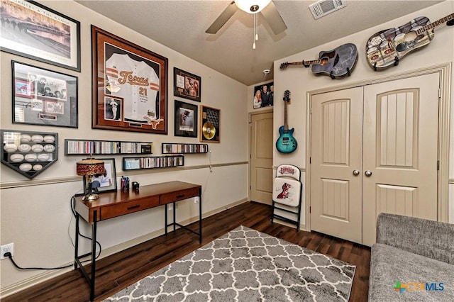 sitting room with dark wood-type flooring and ceiling fan