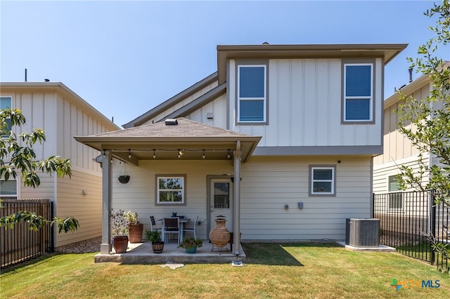 back of house with a yard, central AC unit, board and batten siding, a patio area, and fence