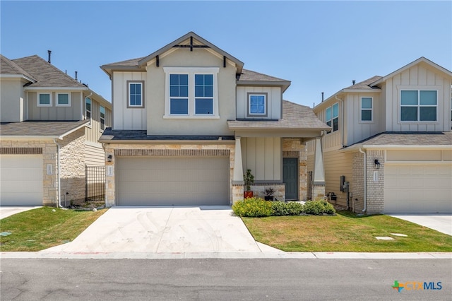 craftsman-style home with an attached garage, brick siding, driveway, a front lawn, and board and batten siding