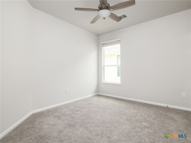 carpeted empty room featuring visible vents, ceiling fan, and baseboards