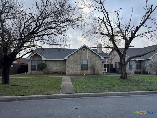 5118 Colonel Travis St, Temple, TX 76502 - view of front of house with brick siding, a front yard, and a chimney