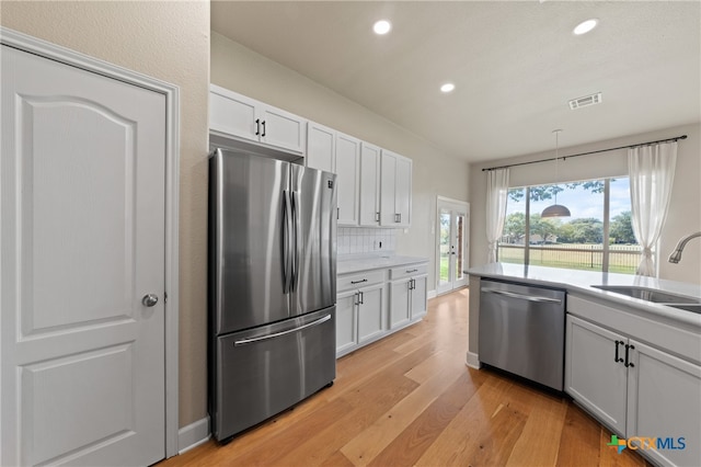 kitchen featuring white cabinets, appliances with stainless steel finishes, light hardwood / wood-style floors, and sink