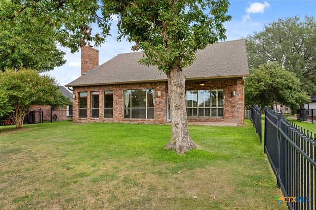4512 Sunflower Ln, Temple, TX 76502 - back of property with a chimney, brick siding, and a shingled roof