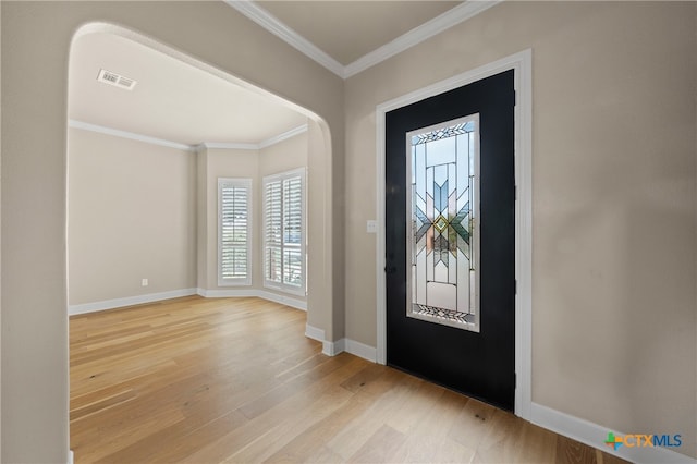 entrance foyer with ornamental molding and light hardwood / wood-style floors