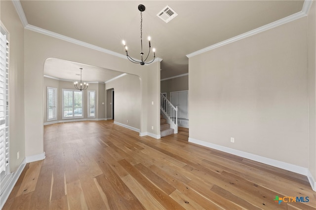 unfurnished dining area featuring hardwood / wood-style floors, a chandelier, and crown molding