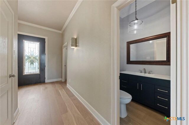4512 Sunflower Ln, Temple, TX 76502 - bathroom with wood finished floors, ornamental molding, toilet, vanity, and baseboards