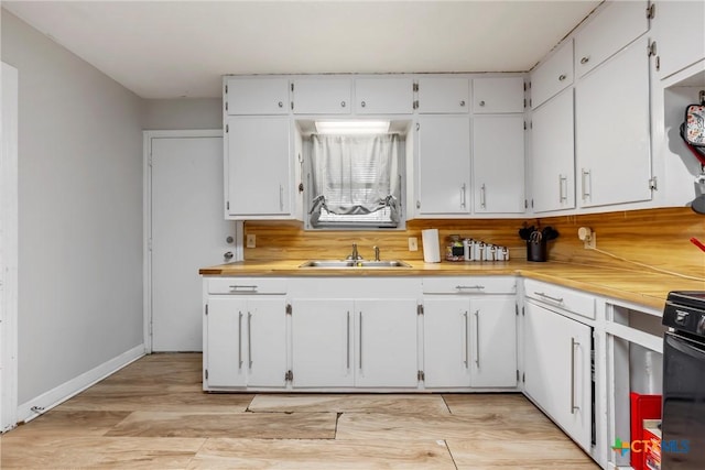 kitchen with white cabinetry, sink, electric range, and light hardwood / wood-style floors