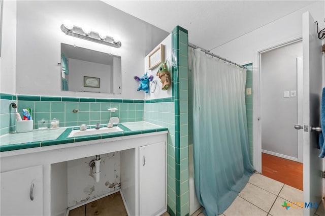 bathroom featuring vanity, tile patterned floors, and tile walls