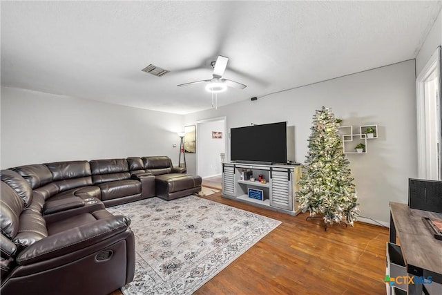 living room featuring ceiling fan, wood finished floors, and visible vents