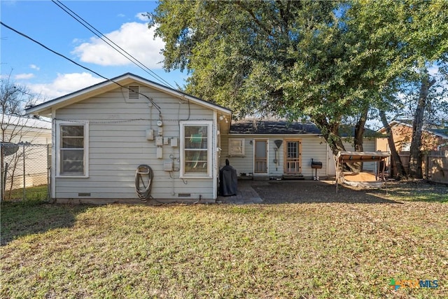 rear view of property featuring a patio area and a yard