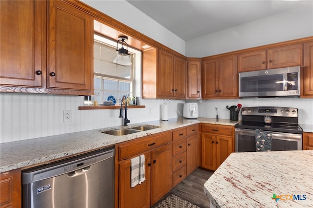 kitchen featuring stainless steel appliances, sink, and light stone countertops