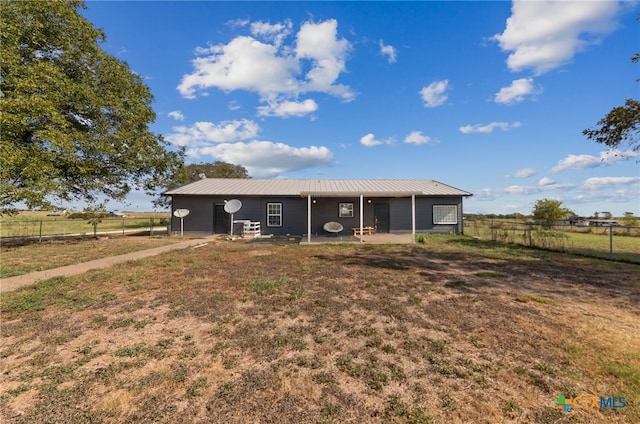 view of front facade featuring a rural view and a front lawn