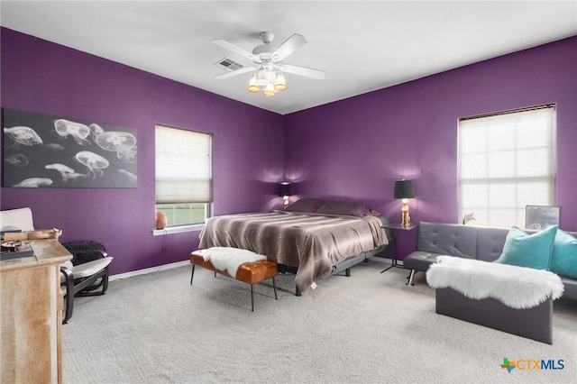 carpeted bedroom featuring ceiling fan and multiple windows