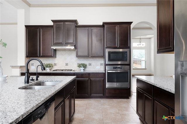 8235 Shining Elk, Garden Ridge, TX 78266 - kitchen with stainless steel appliances, tasteful backsplash, light stone countertops, arched walkways, and ornamental molding
