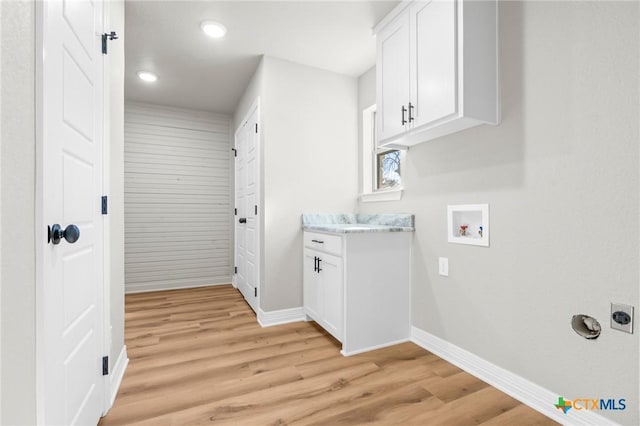 laundry room with light wood-type flooring, electric dryer hookup, hookup for a washing machine, and cabinets