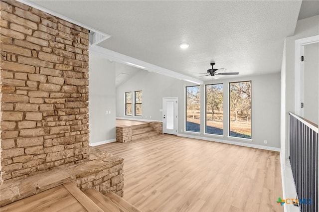 unfurnished living room featuring ceiling fan, a textured ceiling, and light wood-type flooring