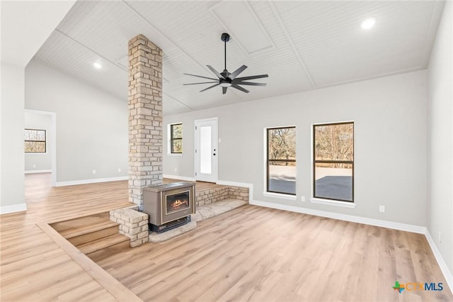 unfurnished living room featuring high vaulted ceiling, ceiling fan, ornate columns, and light hardwood / wood-style flooring