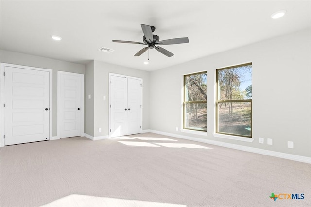 unfurnished bedroom with ceiling fan and light carpet