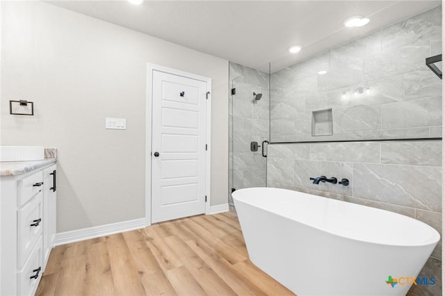 bathroom featuring vanity, shower with separate bathtub, and hardwood / wood-style floors