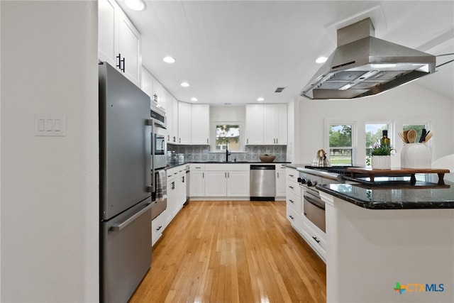 456 Magazine Ave, New Braunfels, TX 78130 - kitchen featuring island range hood, appliances with stainless steel finishes, decorative backsplash, recessed lighting, and light wood-type flooring