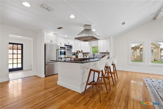 456 Magazine Ave, New Braunfels, TX 78130 - kitchen featuring island exhaust hood, stainless steel appliances, white cabinetry, a kitchen bar, and recessed lighting