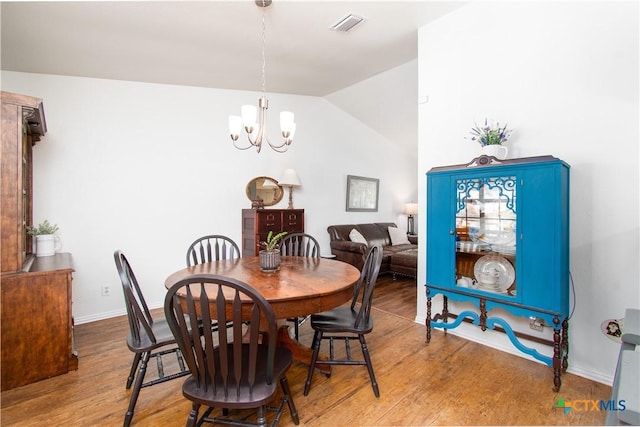 2210 Buckskin Trl, Temple, TX 76502 - dining room featuring lofted ceiling, wood finished floors, a chandelier, and baseboards