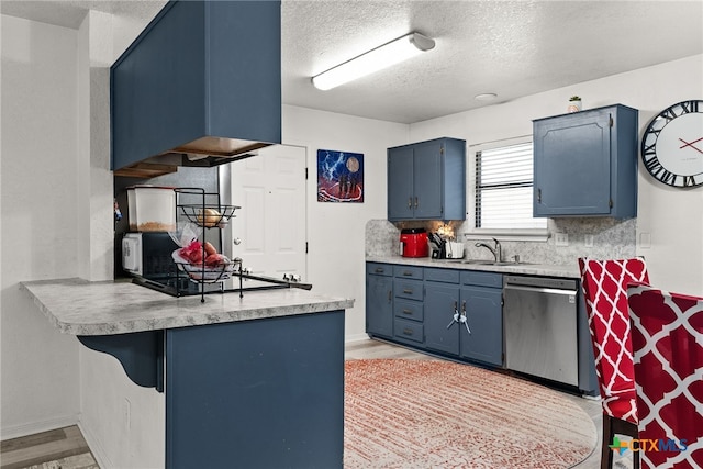 kitchen with sink, a textured ceiling, backsplash, stainless steel dishwasher, and light wood-type flooring