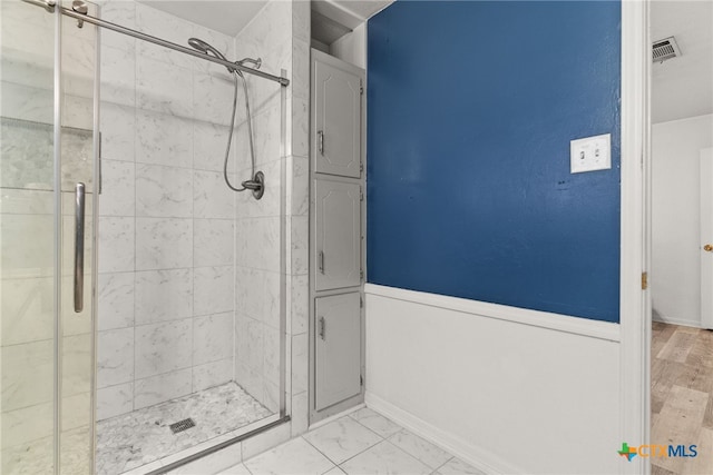 bathroom featuring walk in shower and hardwood / wood-style flooring