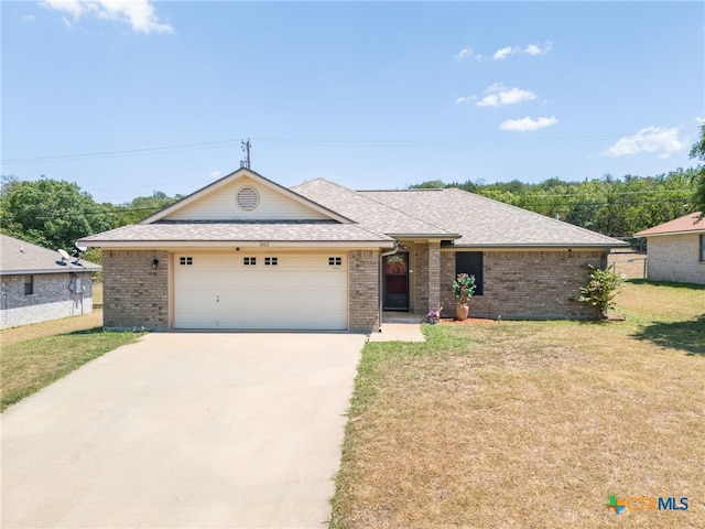 single story home featuring a garage and a front yard