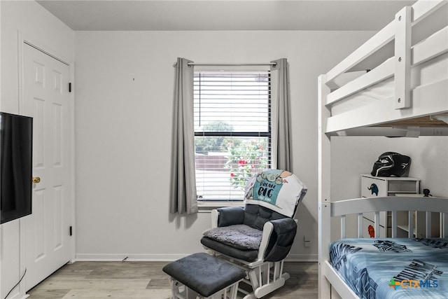 bedroom with light hardwood / wood-style floors and multiple windows