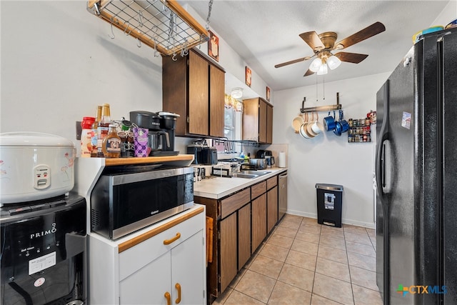 kitchen featuring stainless steel appliances, light tile patterned flooring, white cabinetry, sink, and ceiling fan