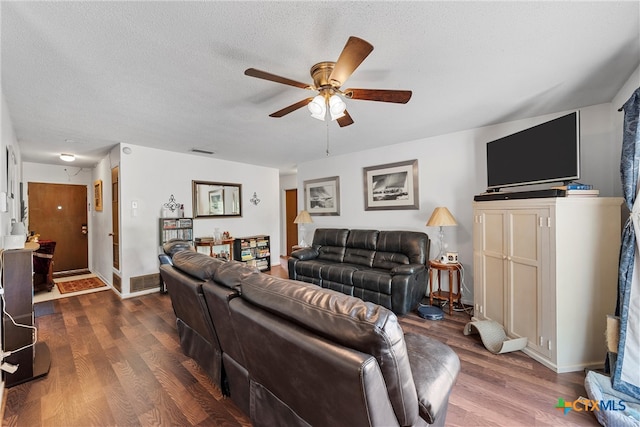 living room featuring ceiling fan, wood-type flooring, and a textured ceiling