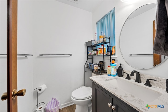 bathroom with vanity, hardwood / wood-style flooring, and toilet