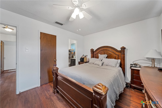 bedroom featuring a textured ceiling, ceiling fan, and dark hardwood / wood-style floors