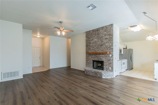 21 Artesian Dr, Belton, TX 76513 - unfurnished living room with light wood-style floors, a ceiling fan, a brick fireplace, a chandelier, and vaulted ceiling