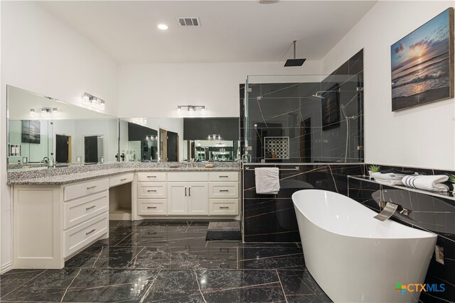 bathroom with vanity and shower with separate bathtub