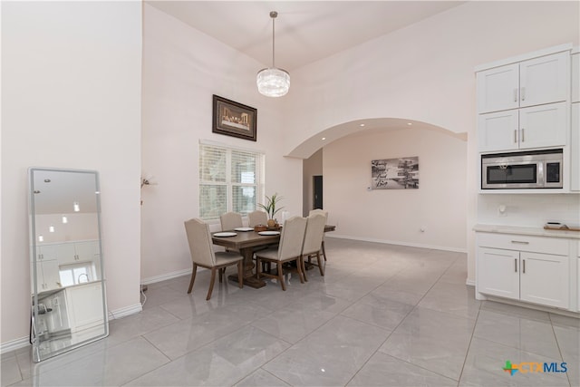 dining area featuring a towering ceiling